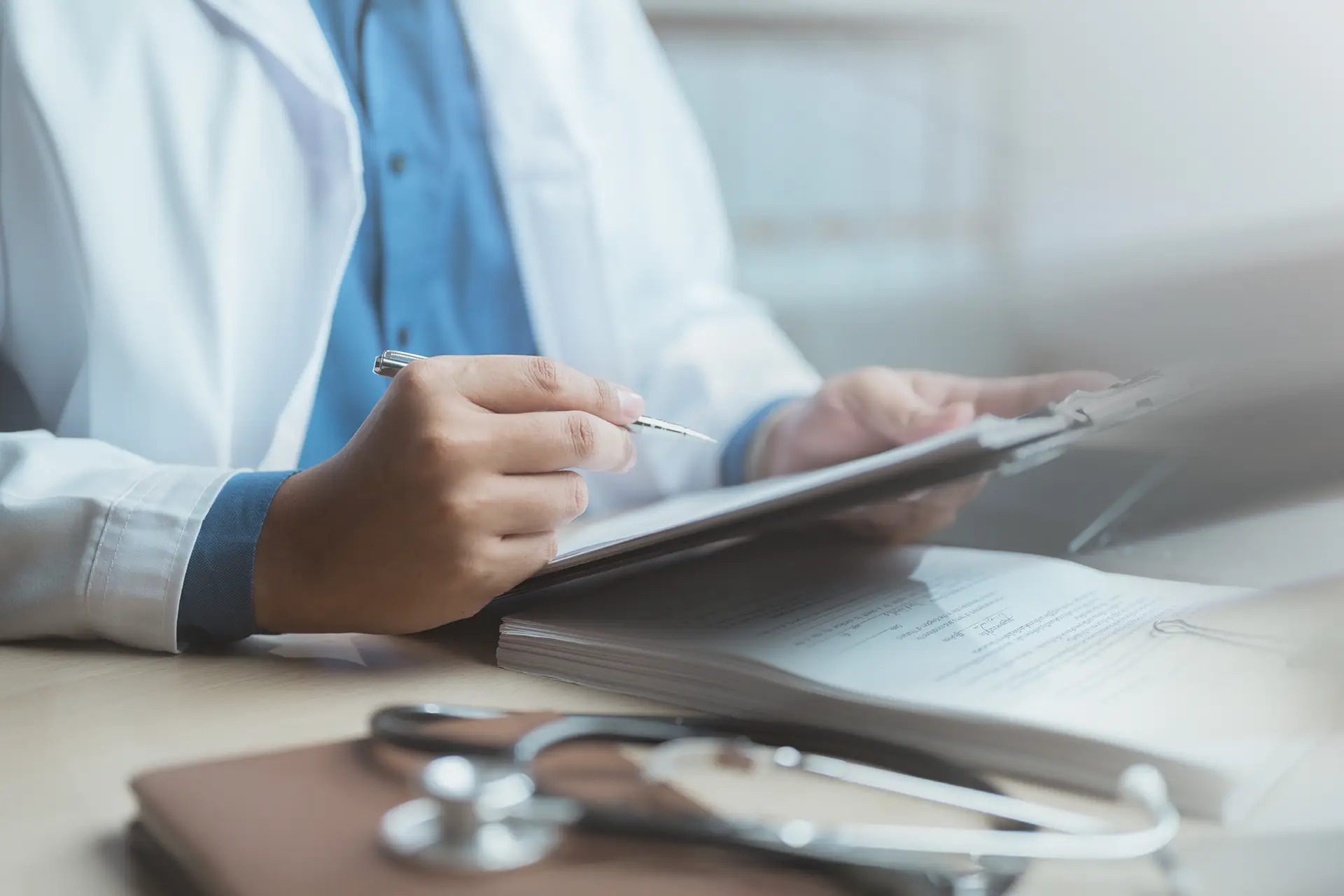 An image of a physician charting on a patient's medical record, indicating the personalized attention patients will receive in the Concierge Program with Dr. Bijoy John at Sleep Wellness Clinics of America.